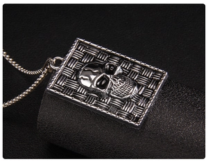 Macro detail of gothic skull pendant with woven texture on silver metal chain