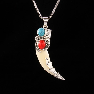 Vintage tribal wolf tooth pendant necklace with turquoise and red stones on black background