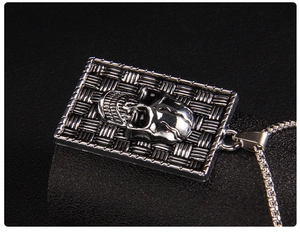 Detail of gothic square pendant with textured woven pattern and 3D skull on a box chain