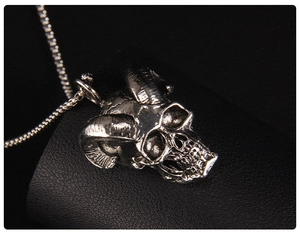 Macro view of gothic bull horn skull pendant with detailed silver metallic texture