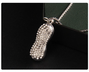 Vue macro d'un pendentif cacahuète pavé de cristaux sur une chaîne maille miroir