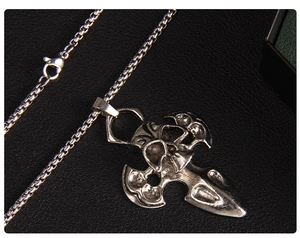 Detail of vintage silver skull and cross pendant with dagger on a box chain