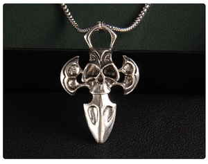 Detailed view of punk skull and battle axe pendant with vintage silver finish and chain
