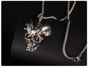 Macro shot of gothic ram horn skull pendant with antique silver finish on black leather