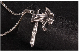 Vue détaillée du pendentif hache avec gravure de crâne sur une chaîne corde