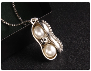 Vue macro du pendentif cacahuète argenté avec perles et cristaux sur une chaîne box