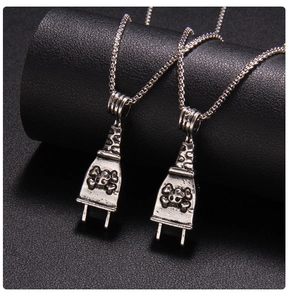 Macro shot of punk style silver plug pendants with skull motif on black leather texture