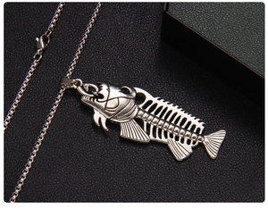 Macro shot of vintage silver fish bone pendant with detailed rib structure on leather