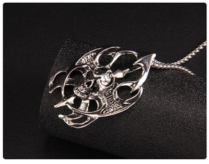 Vue macro d'un pendentif tête de mort punk avec motifs de flammes sur socle noir