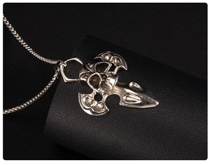 Macro detail of gothic skull and sword pendant with vintage silver finish on bead chain