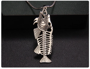 Detailed macro view of punk style piranha fish bone pendant on a beaded chain necklace