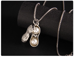 Vue détaillée du pendentif cacahuète avec cristaux et deux perles à l'intérieur