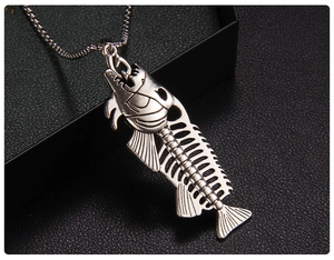 Macro shot of vintage silver fish bone pendant with punk style details on black leather