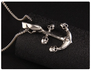 Detailed close-up of retro silver anchor pendant featuring gothic skull elements