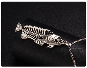 Macro shot of silver fish bone skeleton pendant with vintage punk metal texture