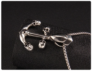 Macro shot of anchor pendant with skull detail in antique silver finish on a box chain