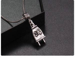 Macro shot of vintage silver plug pendant with skull pattern and hammer-textured surface