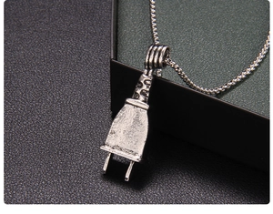 Macro detail of industrial punk style skeleton plug pendant with distressed silver finish