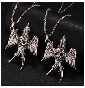 Detailed view of silver gothic skull eagle pendants on black leather background