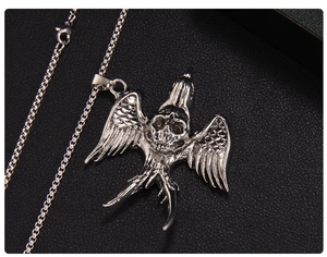 Detailed close-up of gothic skull pendant with bird wings on a silver box chain necklace