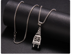 Close-up of punk style plug pendant with 3D skull design on a vintage metal chain