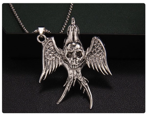 Gothic punk necklace detail featuring an antique silver skull pendant with bird wings