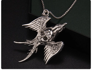 Close-up of gothic swallow skull pendant with silver alloy finish and beaded chain
