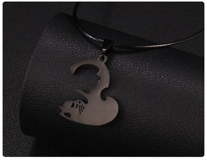 Gros plan détaillé d'un pendentif silhouette de chat noir mat sur un fond en cuir texturé