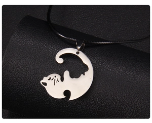 Vue détaillée du pendentif chat en acier inoxydable argenté sur cordon en cuir noir