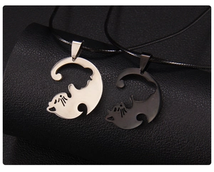 Détail des colliers chat emboîtables en argent et noir sur fond de cuir texturé noir