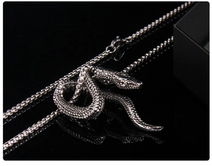 Macro view of vintage punk style snake pendant with detailed scales on black surface
