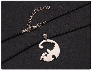 Détail d'un pendentif silhouette chat en acier inoxydable argenté sur un cordon noir ajustable