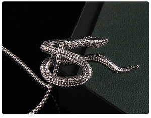 Macro shot of silver stainless steel snake pendant with detailed scales and box chain