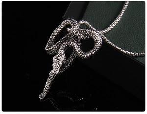 Macro view of vintage silver snake pendant with detailed scales and box chain