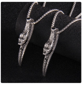 Détail des pendentifs double tête de serpent avec texture d'écailles sur une chaîne