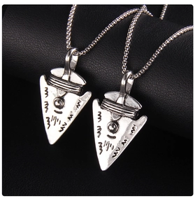 Detailed view of silver Viking shield pendant with tribal engraving on black leather