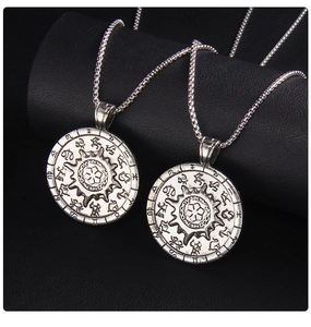 Detailed close-up of retro silver sun compass necklaces with zodiac embossing