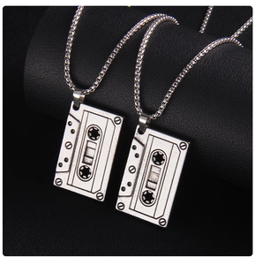 Détail macro de pendentifs cassettes rétro avec finition argentée vintage sur cuir noir