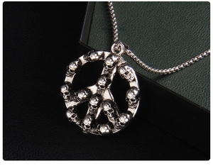 Close-up of punk peace symbol pendant featuring small skulls and silver box chain