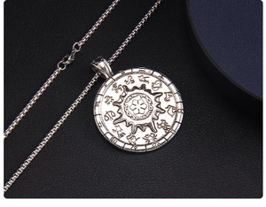 Macro detail of vintage stainless steel solar compass necklace with zodiac symbols