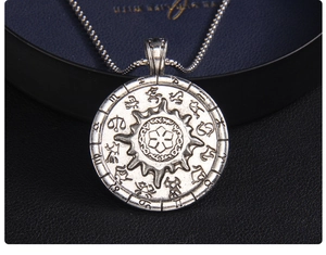 Macro detail of vintage sun compass pendant featuring twelve zodiac signs and sun pattern