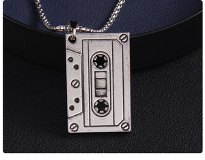Vue macro du pendentif cassette rétro avec finition vintage sur cuir noir élégant
