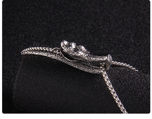 Détail d'un pendentif tête de serpent en argent avec textures d'écailles sur chaîne box