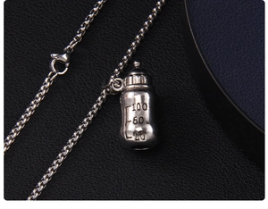 Vue macro du pendentif biberon en acier inoxydable avec gravures d'échelle sur chaîne
