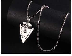 Macro shot of Viking shield arrow pendant with tribal engravings and box chain necklace