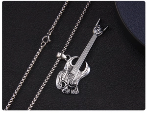 Detail of rock punk guitar pendant with skull and hand sign on stainless steel chain