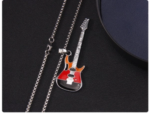 Vue macro d'un pendentif guitare avec émail rouge sur une chaîne à billes argentée