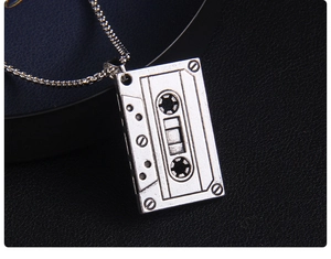 Gros plan du pendentif cassette rétro argenté avec texture métallique industrielle