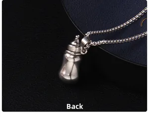 Vue macro du dos d'un pendentif en forme de biberon argenté en acier inoxydable
