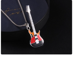 Macro du pendentif guitare en émail coloré avec chaîne box sur un écrin à bijoux